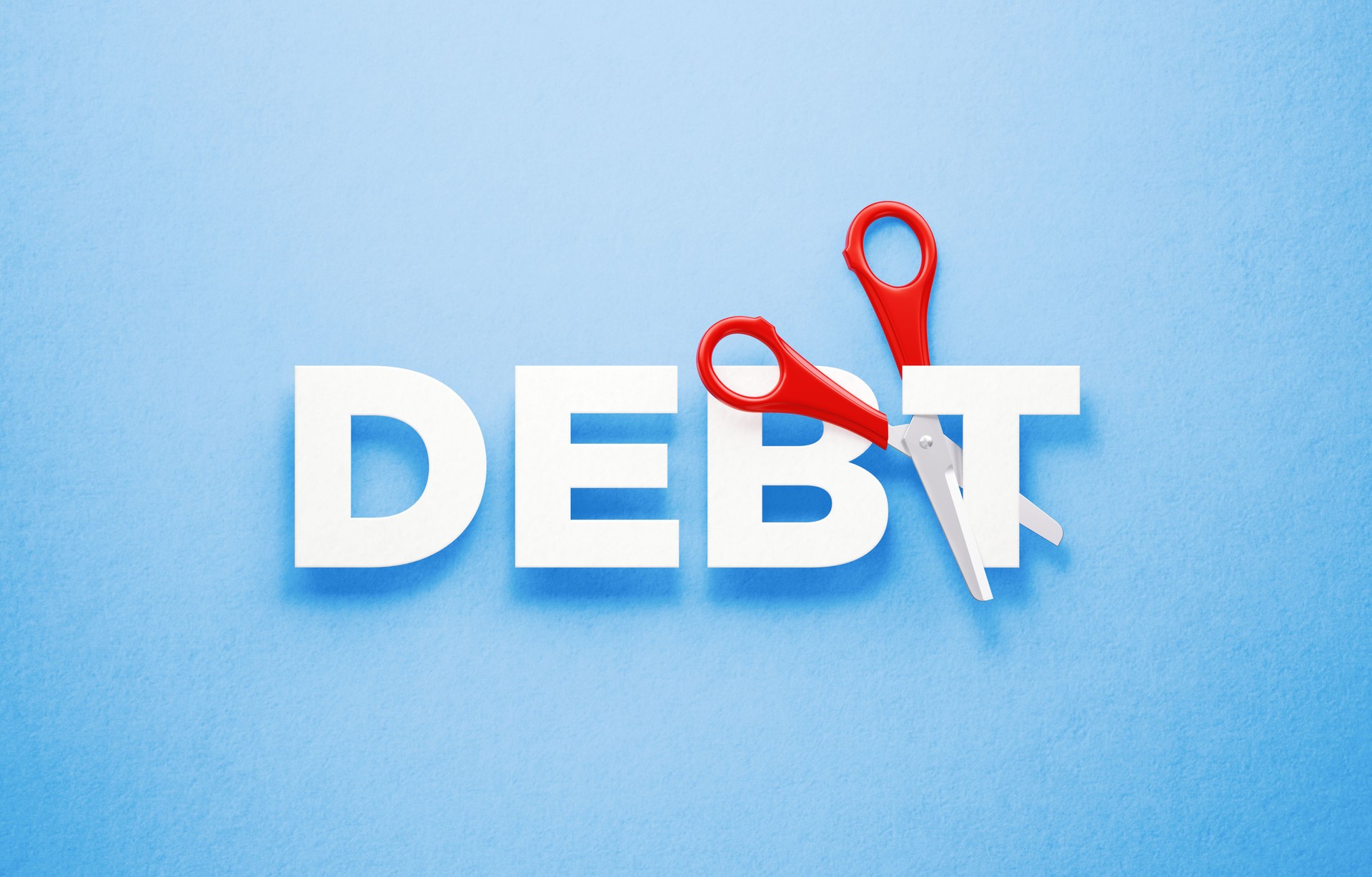 Cutting Debts Concept - Scissors Cutting The Word Debt Over Blue Background